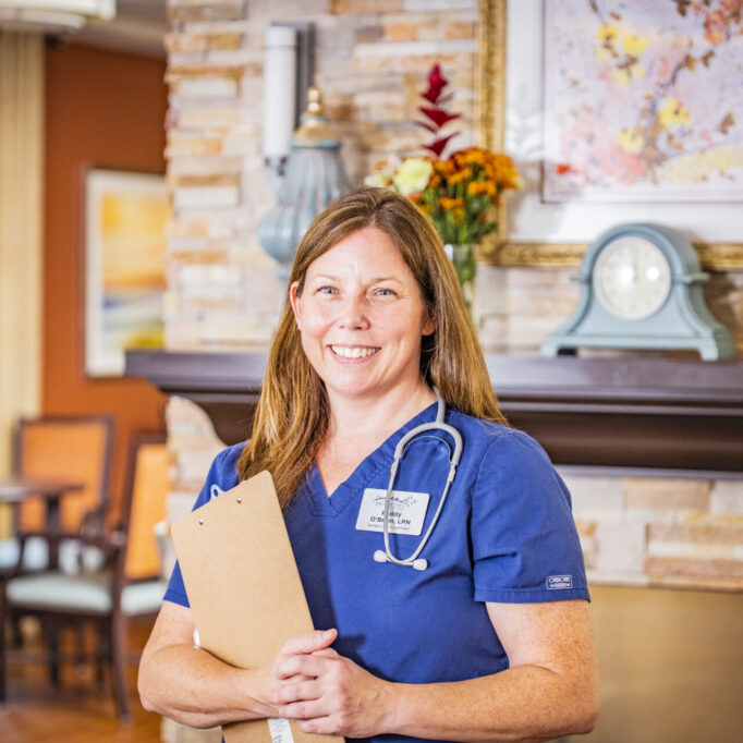 Nurse smiling in a cozy interior space.