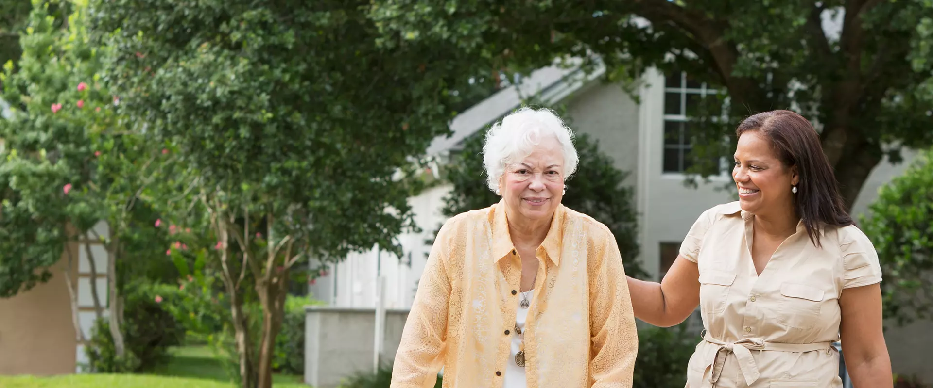 Senior woman walking with staff in garden area