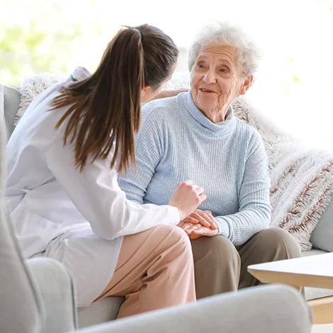Nurse interacting with an elderly resident indoors.