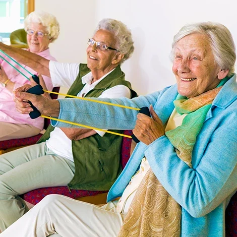 Seniors participating in a group exercise activity indoors.