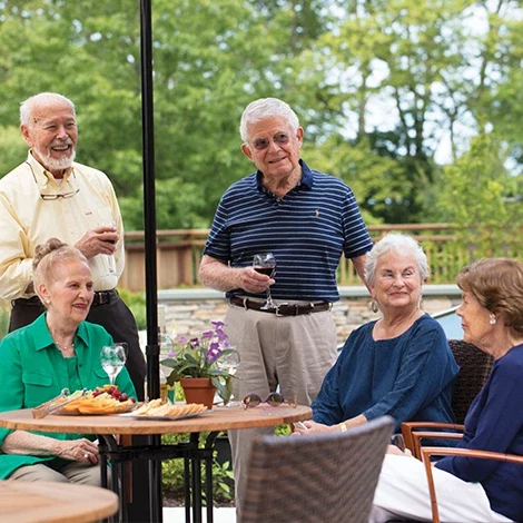 A group of seniors enjoying drinks outdoors.