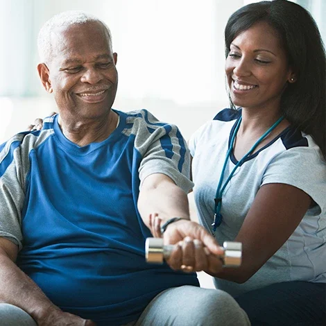 Senior exercising with staff assistance