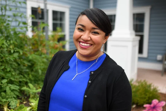 Smiling staff member in a garden area
