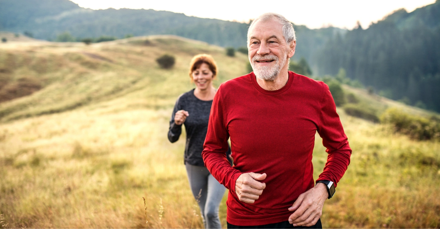 Seniors jogging in a scenic outdoor area.