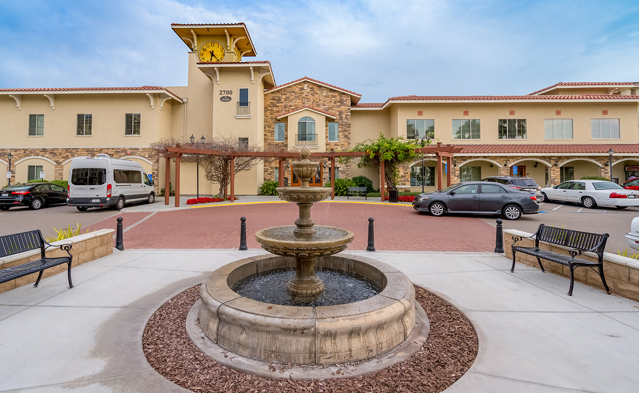 Exterior view of facility with fountain and cars