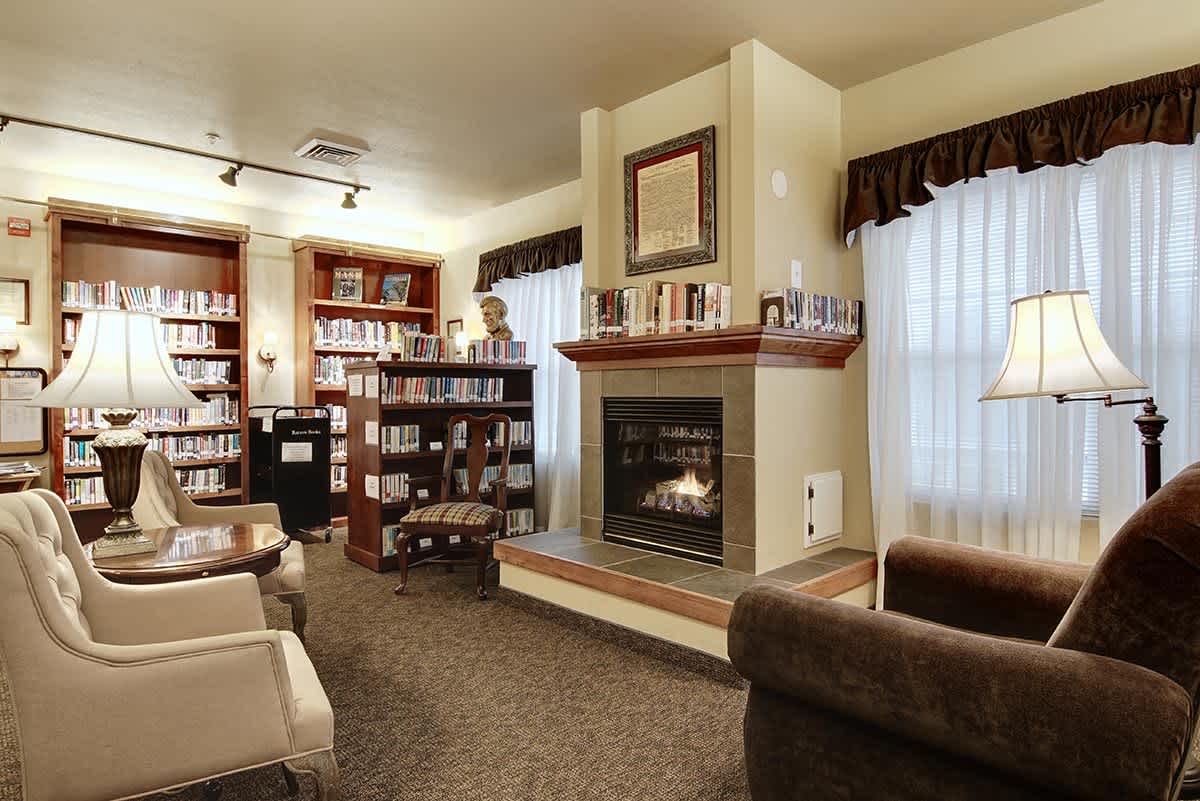 Cozy library and reading area with a fireplace.