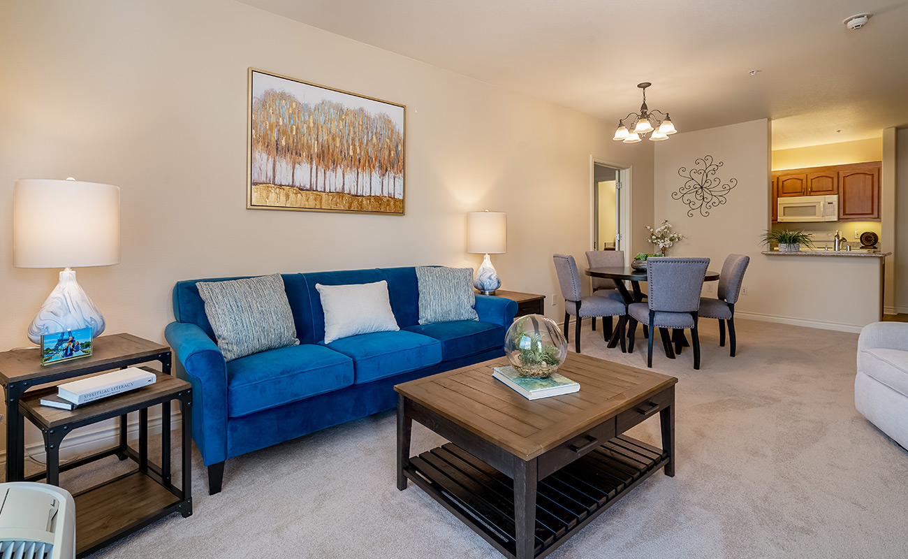 Cozy living area with blue couch and dining table.