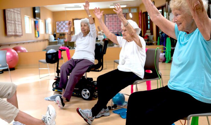 Residents engaged in a seated exercise class