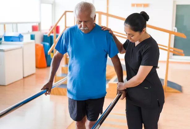 A senior man receiving assistance during rehabilitation.