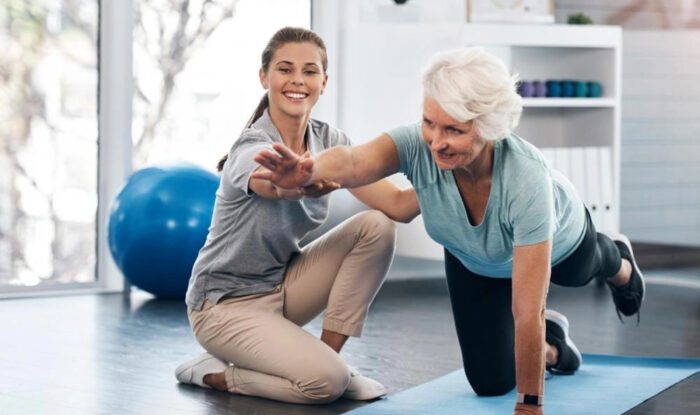 Resident engaging in exercise with staff assistance
