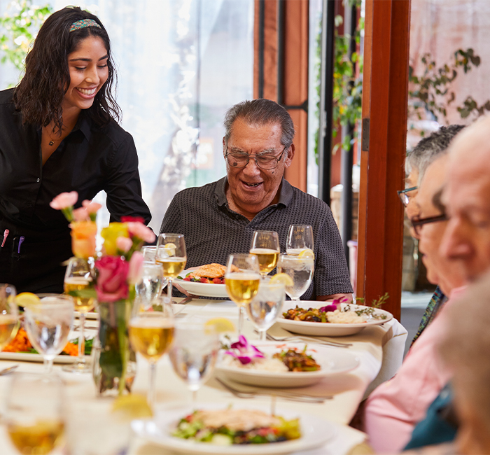 Residents enjoying a meal with a staff member