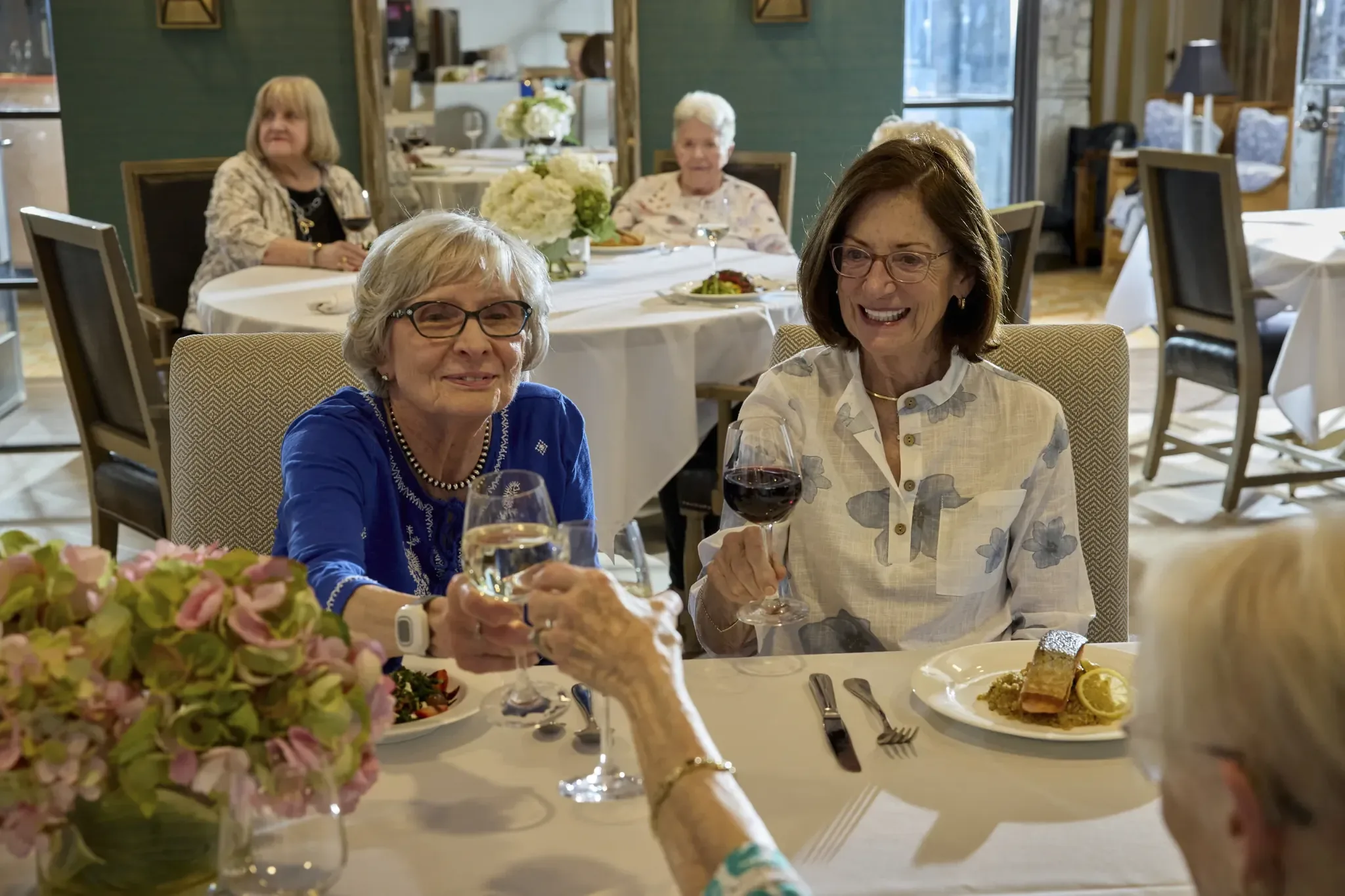 Residents enjoying a toast at a dining table.