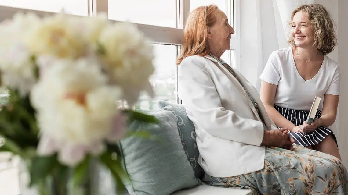 A resident and staff member chatting in a cozy setting.