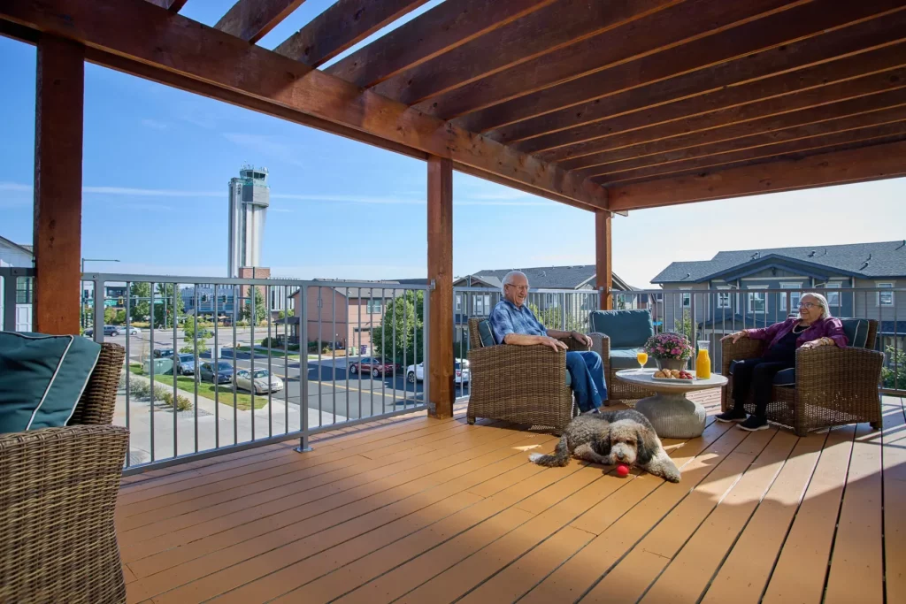 Residents relaxing on a rooftop deck with a dog.