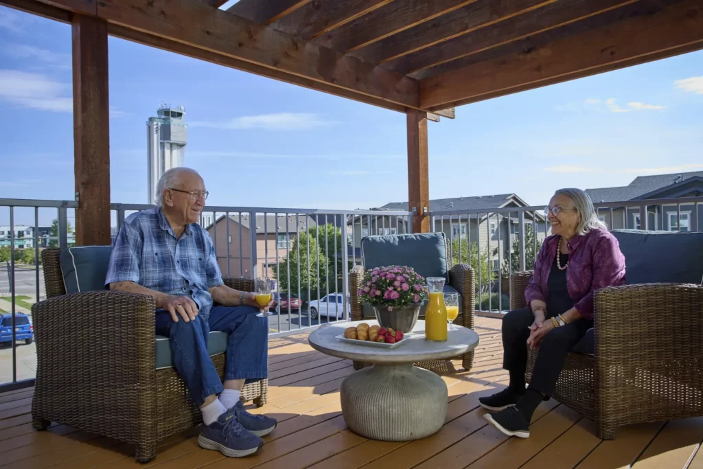 Two residents enjoying a conversation on a balcony.