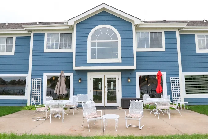 Exterior view of a nursing home building with outdoor seating.