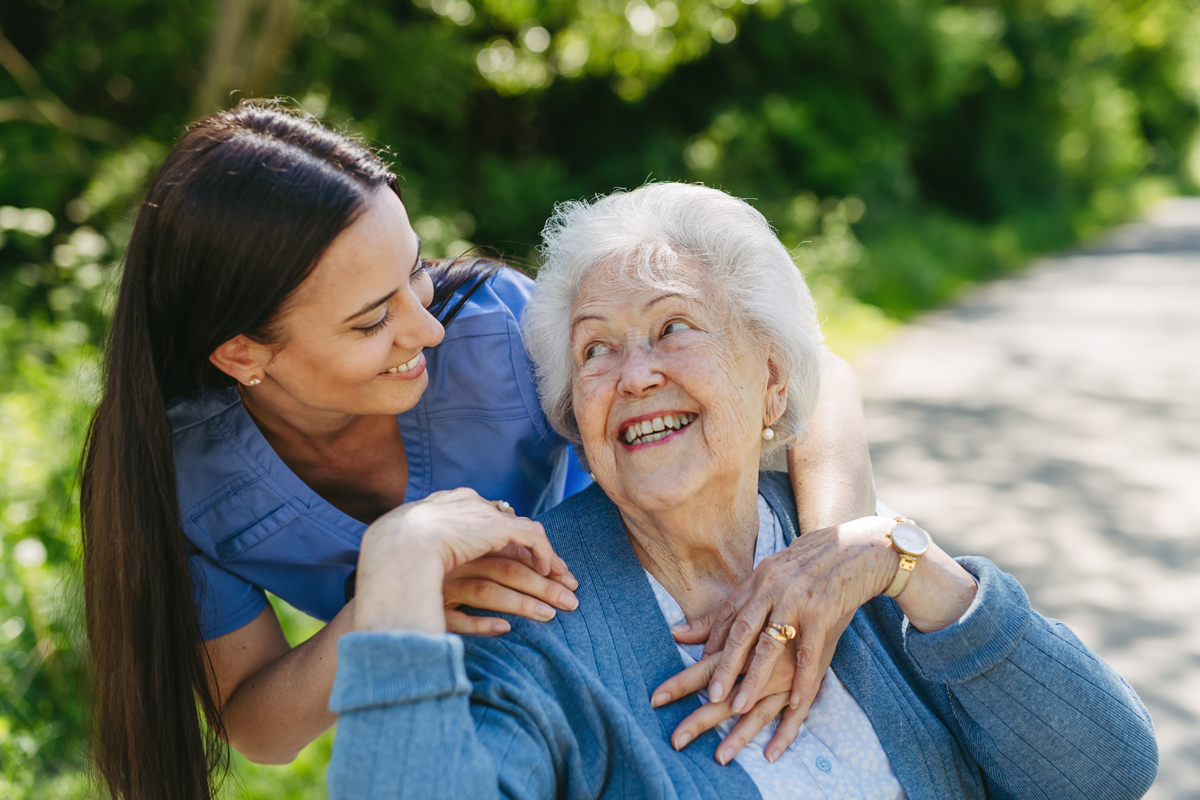 Caregiver interacting with a senior outdoors