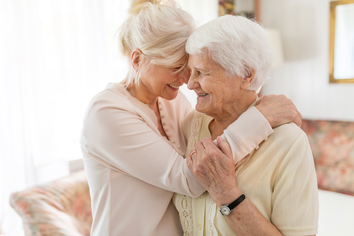 Two women sharing a joyful moment indoors.