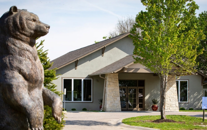Building exterior with bear statue and trees