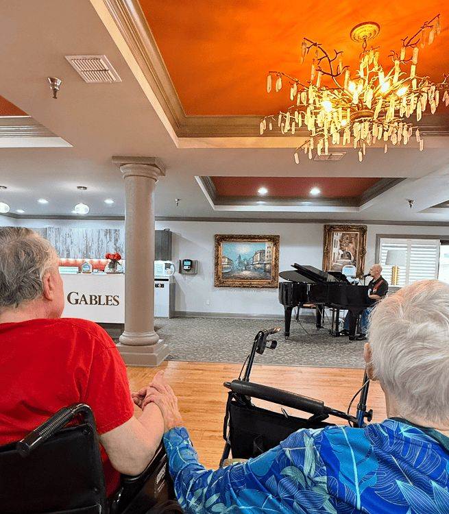Residents enjoying live piano music in common area