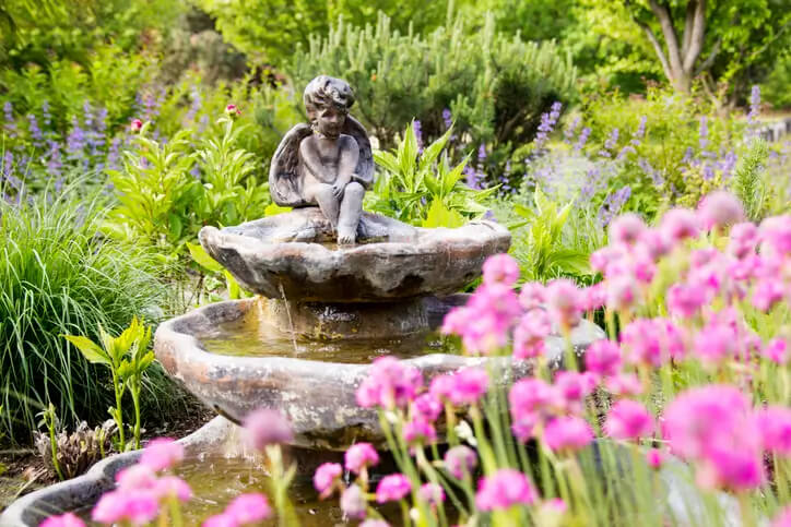 A serene garden with a fountain and flowers.