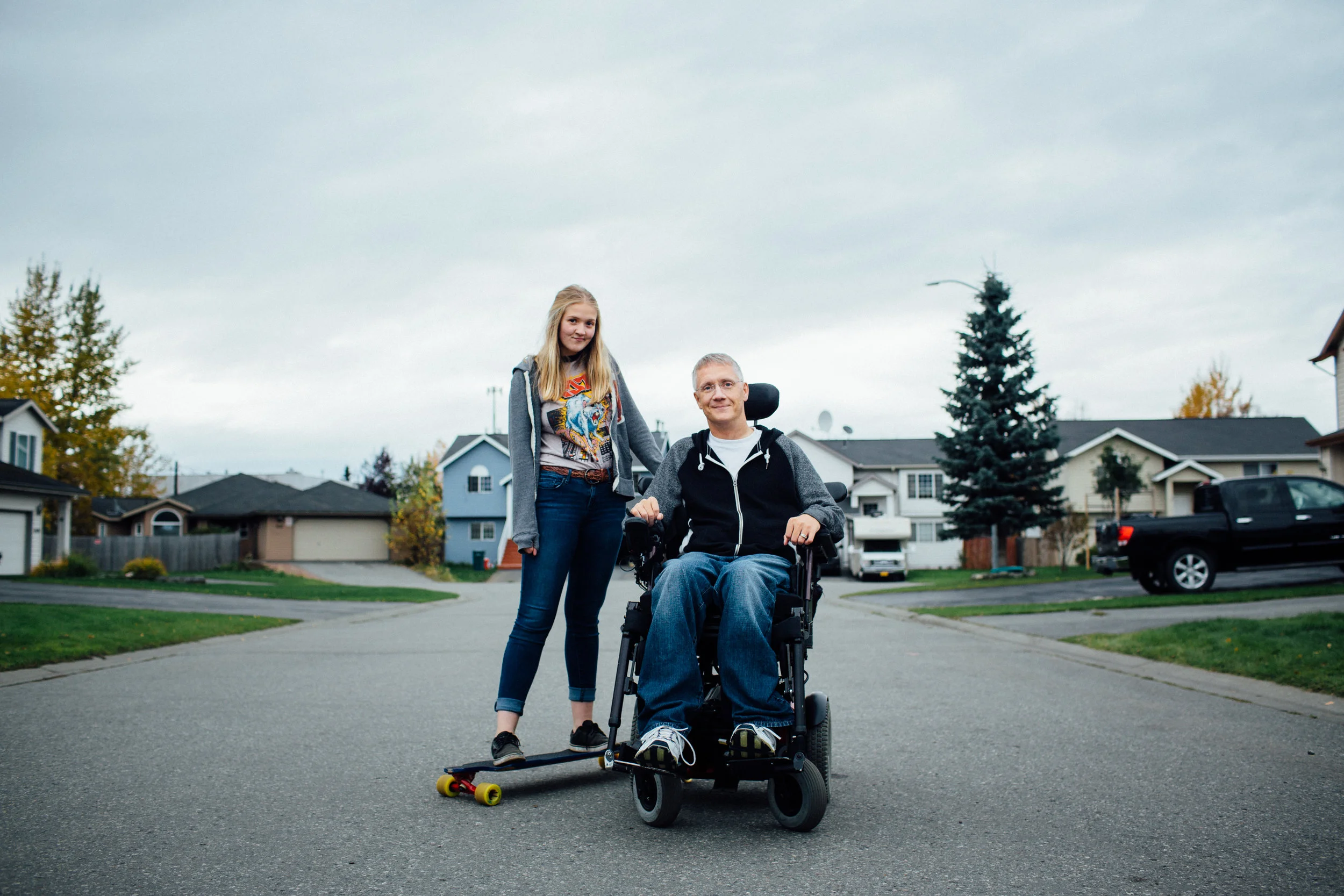 Teen girl and young man in wheelchair outdoors