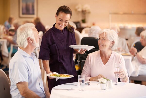 Staff serving residents in a dining area