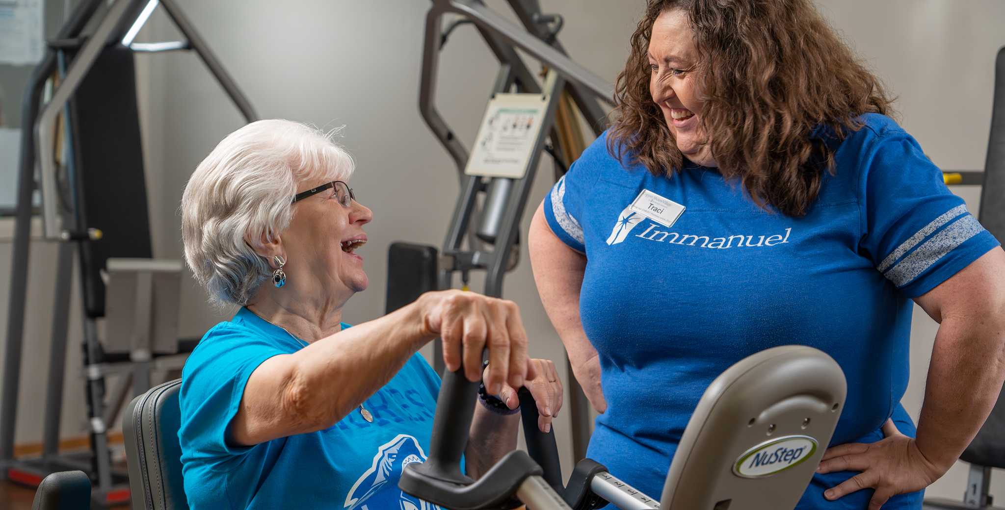 Resident exercising with staff member in fitness area