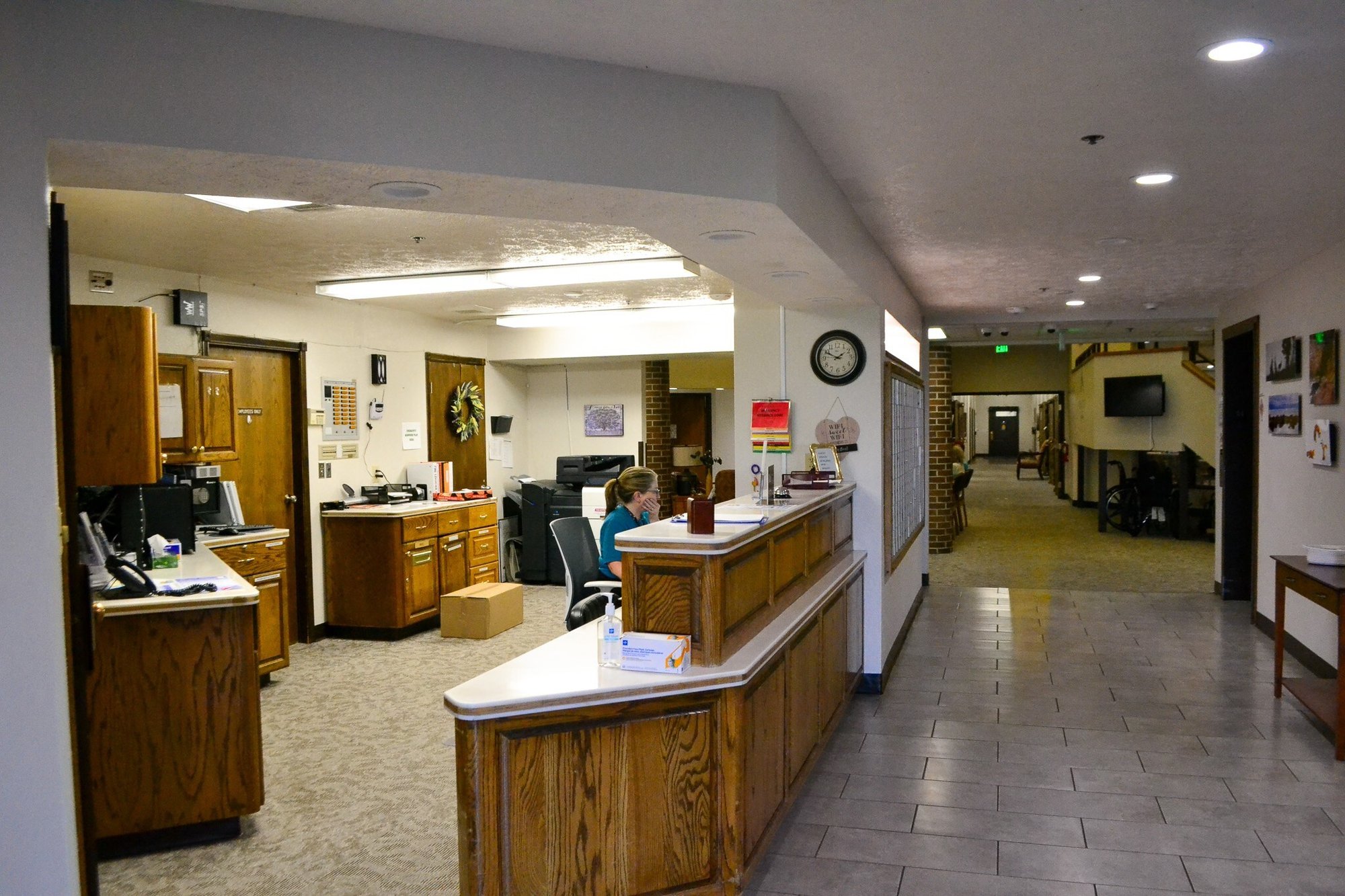 Interior reception area with staff member at desk.