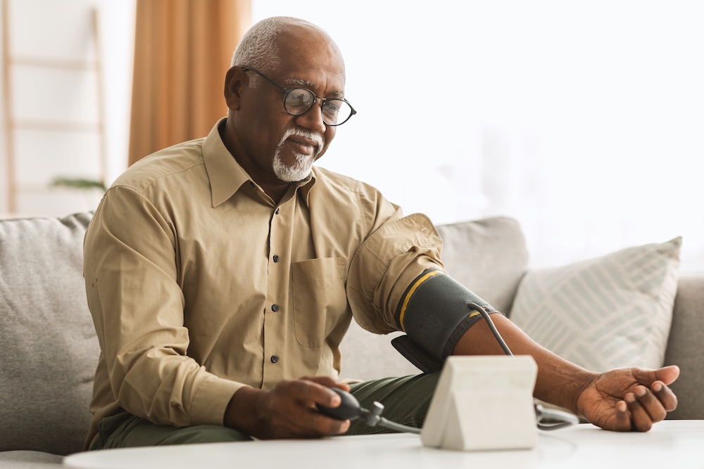Senior man measuring blood pressure at home