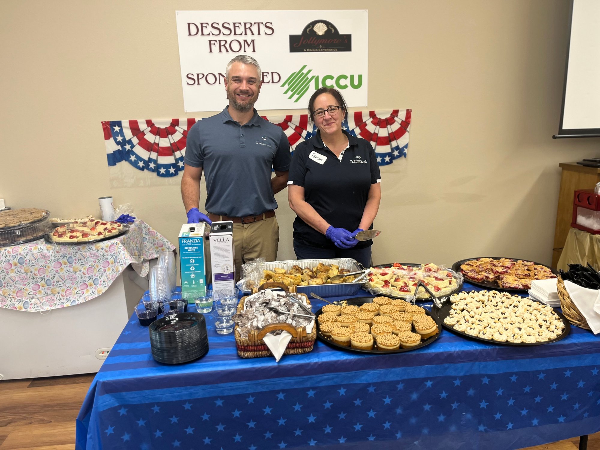 Staff presenting a dessert display at an event.