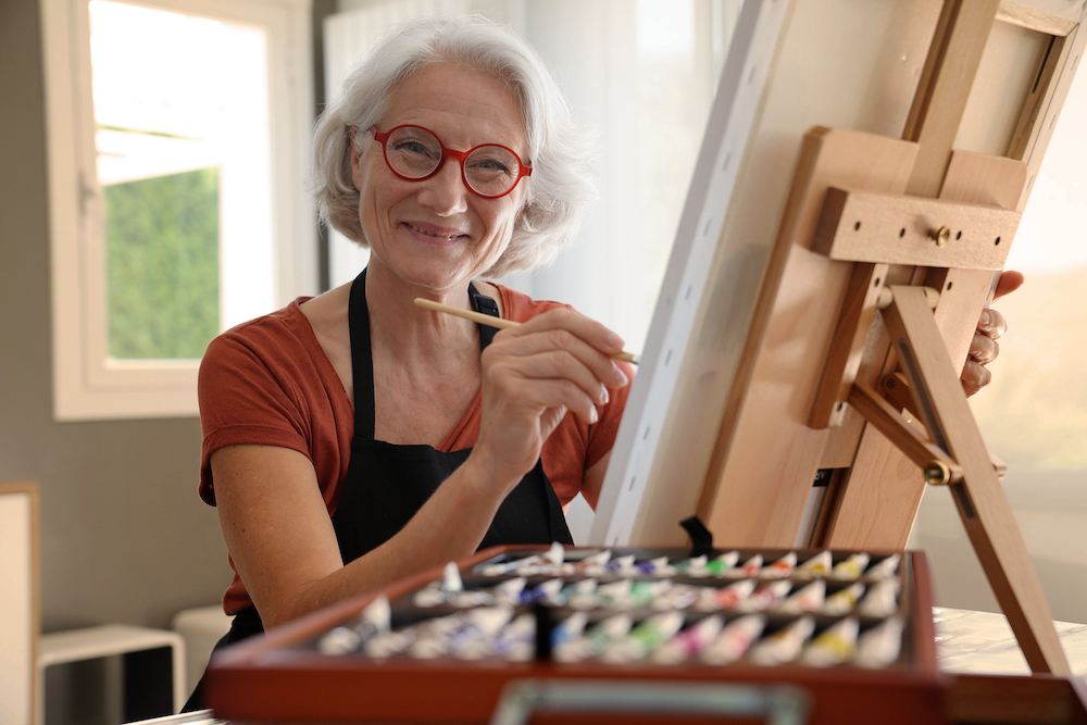 Senior woman painting in an art class.