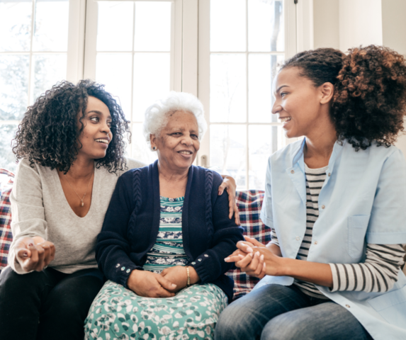Two women and a senior woman chatting indoors
