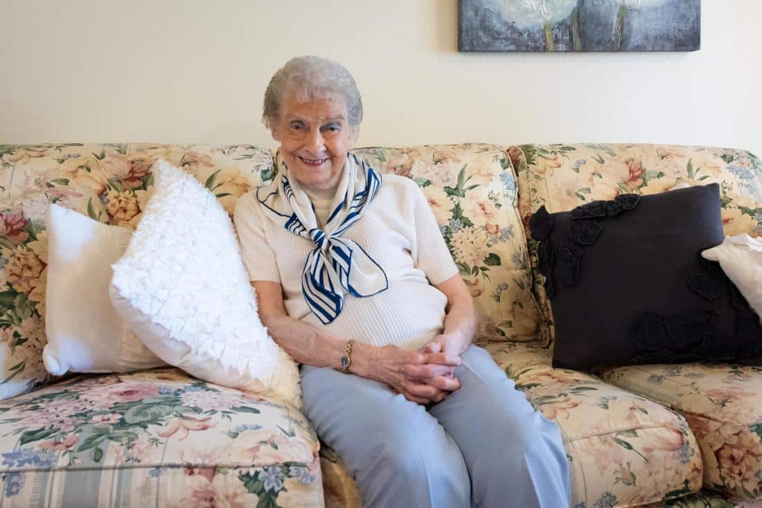 Senior woman sitting on a floral couch