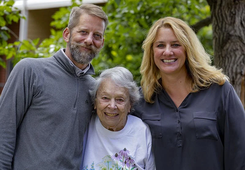 Three people smiling in an outdoor setting