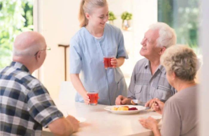Residents enjoying a meal with staff member.