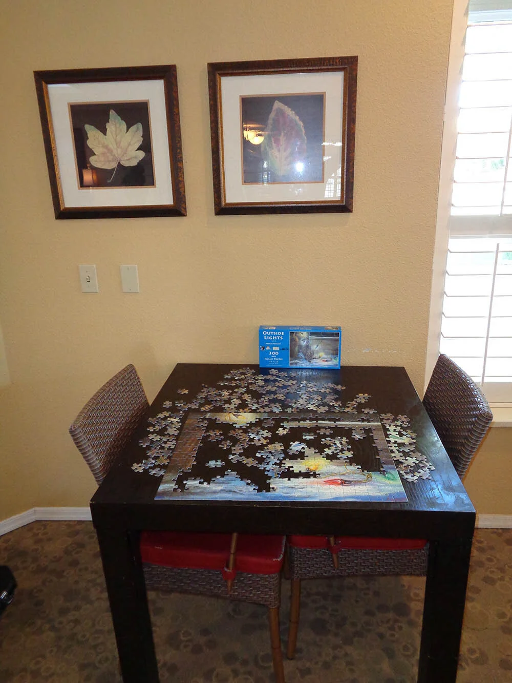 Puzzle on a dining table with framed art.