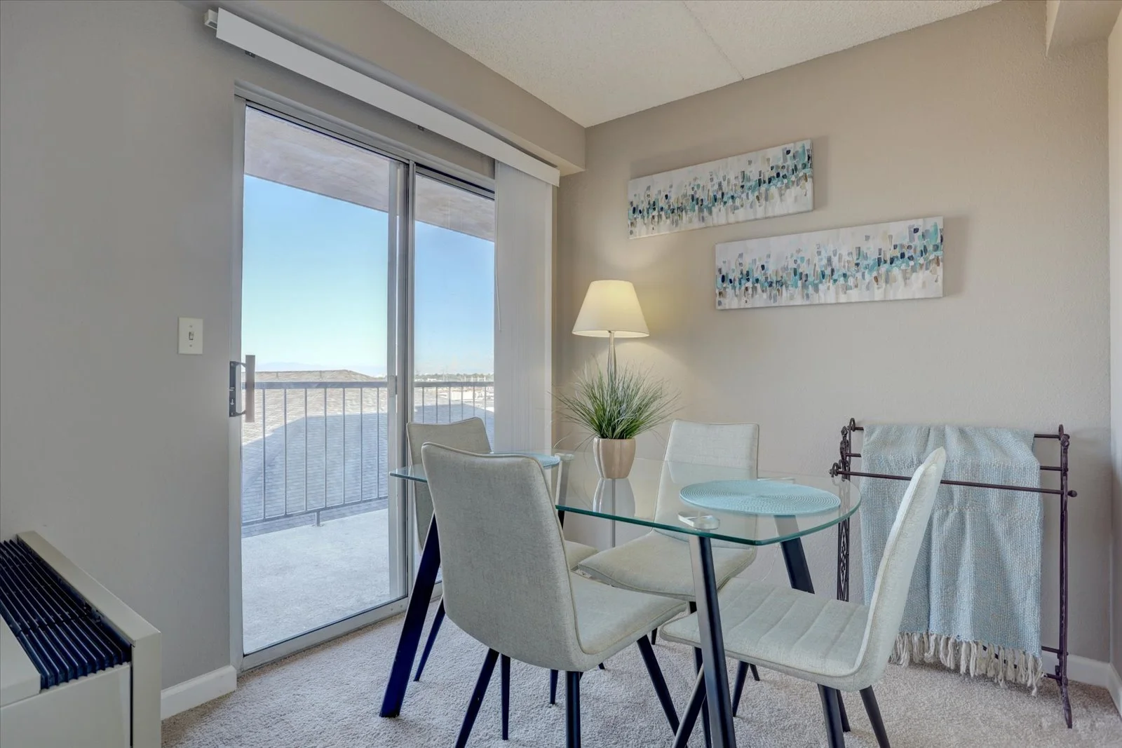Cozy interior with glass table and access to outdoor balcony.