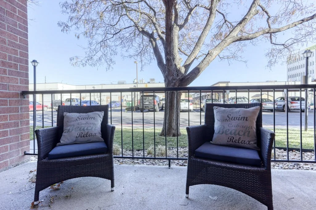 Outdoor seating area with two chairs and cushions.