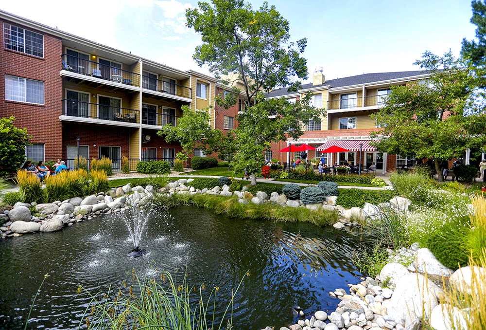 Outdoor space with a pond and residents relaxing