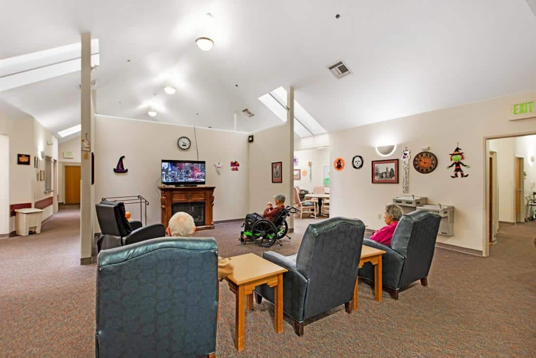 Residents enjoying a common area while watching TV.