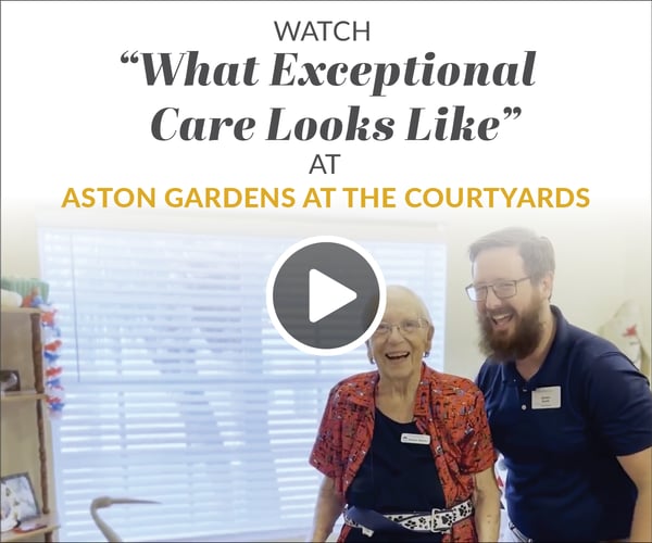 Smiling resident and staff member in an interior space