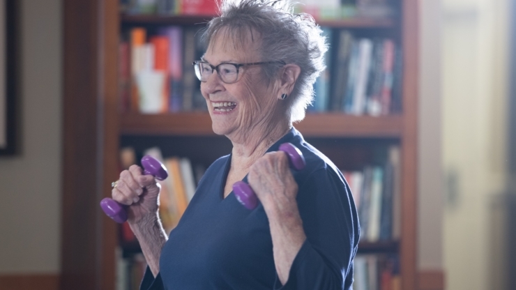 Senior woman exercising with dumbbells in an activity room