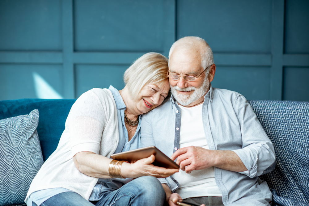 Couple enjoying a tablet together on a couch