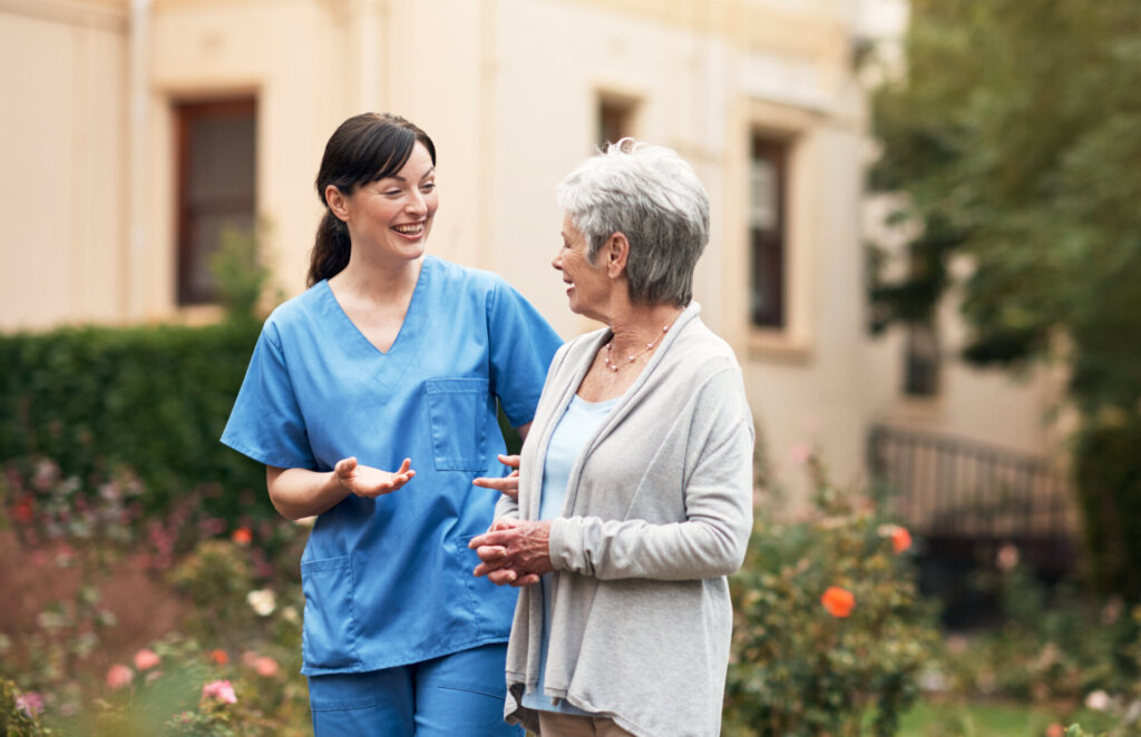 A caregiver chatting with a resident in a garden