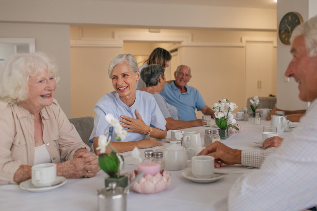 Residents enjoying tea and conversation in a dining room