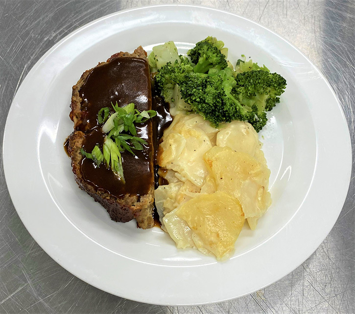 Plate of meatloaf with sides of broccoli and potatoes