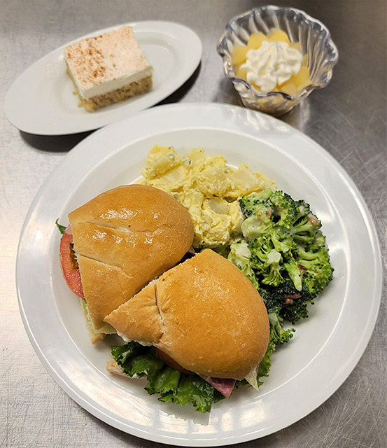 A plated meal featuring sandwiches and desserts