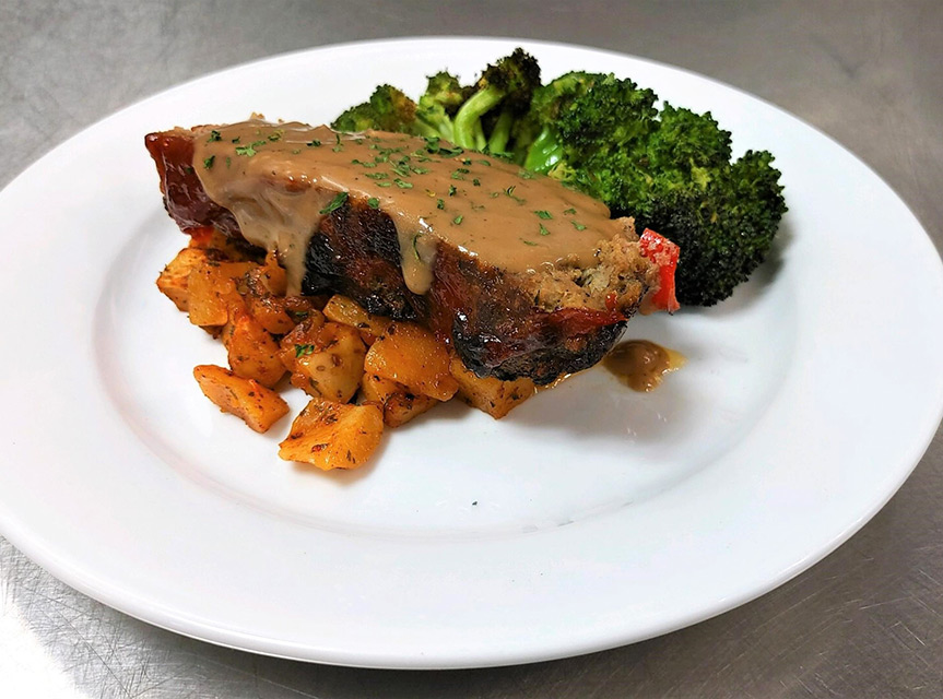 Plate of meatloaf with vegetables on the side