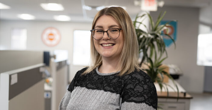 A smiling staff member in a modern office setting